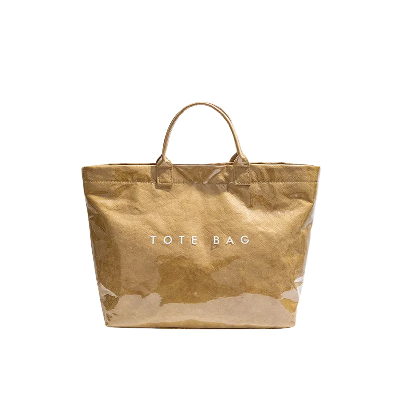A metallic gold tote bag with two top handles and the words 'TOTE BAG' printed in white on the front, shown against a plain white background.