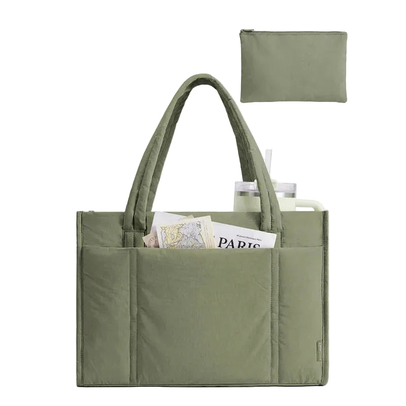 Green tote bag with compartments filled with items, including a book, on a white background.